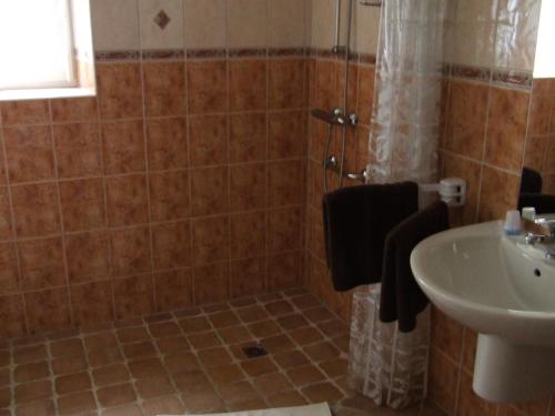 une salle de bain avec un lavabo, des toilettes et une douche dans l'établissement Les Abris de la Sée, à Tirepied