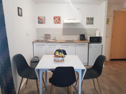 a kitchen with a table with chairs and a cake on it at Appartement en entier in Saint-Junien
