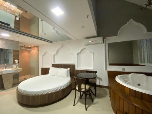 a bedroom with a bed and a bathroom with a sink at Drops Motel Porto Alegre in Porto Alegre