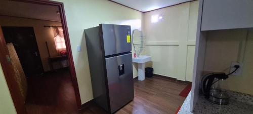 cocina con nevera de acero inoxidable en una habitación en DEBIDIEN APARTMENT, en Paramaribo