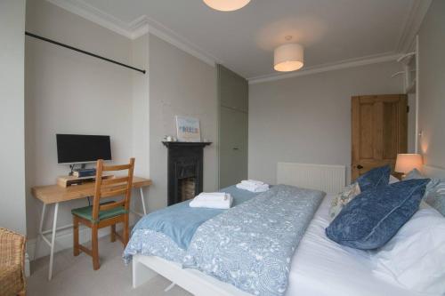 a bedroom with a bed and a desk with a computer at Pass the Keys Cosy Stylish house near Southend in Southend-on-Sea