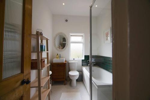 La salle de bains est pourvue de toilettes, d'une baignoire et d'un lavabo. dans l'établissement Pass the Keys Cosy Stylish house near Southend, à Southend-on-Sea