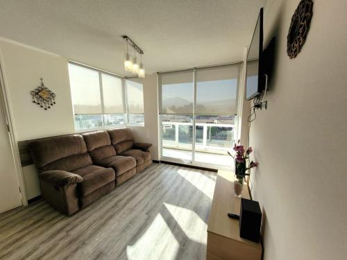 - un salon avec un canapé brun et une table dans l'établissement Condominio Pacífico III, à La Serena