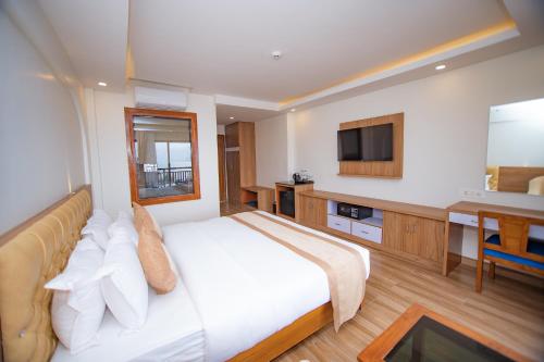 a bedroom with a bed and a desk and a television at Hotel Pokhara Village & SPA in Pokhara