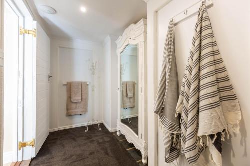 a bathroom with a mirror and towels on the wall at Devon Castle Forest Lodge in Stellenbosch