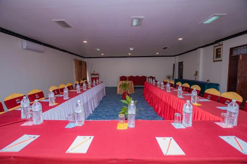 a conference room with red tables and chairs with bottles at Hotel Pokhara Village & SPA in Pokhara