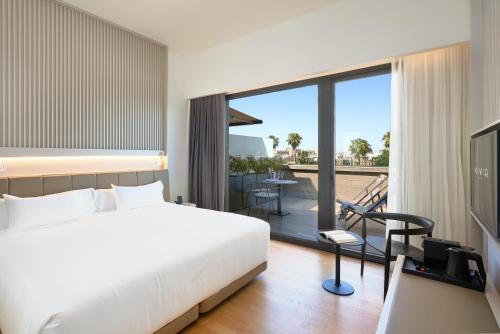 um quarto de hotel com uma cama e uma varanda em Hotel Kivir em Sevilha