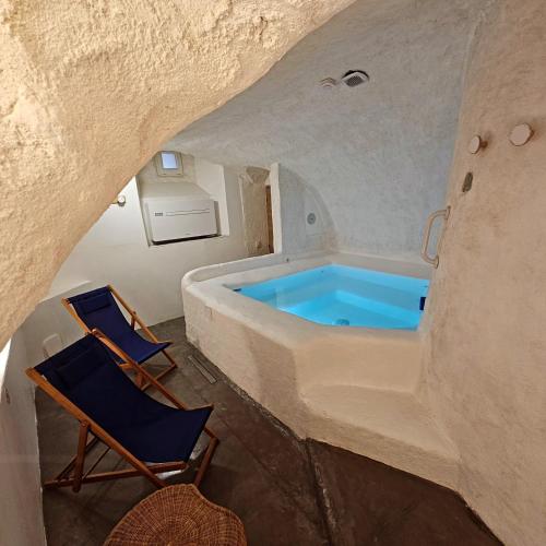 - une baignoire dans une chambre avec 2 chaises dans l'établissement LE GRAND LOGIS, chambre Santorin avec spa privatif, à Le Caire