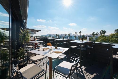 een restaurant met tafels en stoelen op een balkon bij Hotel Kivir in Sevilla