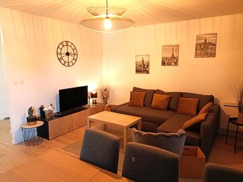 uma sala de estar com um sofá e uma TV em Les vergers de Serris, 6 personnes, 2 PK privés, balcon, lit bébé em Serris