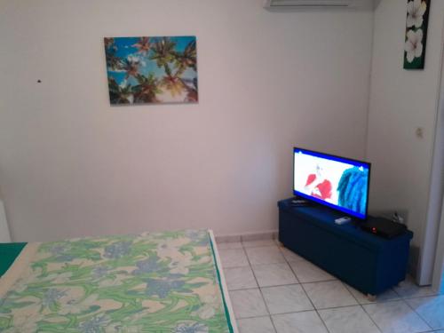 Habitación con TV, cama y mesa. en Studio avec piscine partagee jardin clos et wifi a Baie Mahault, en Baie-Mahault