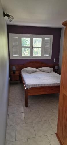 un dormitorio con una cama y una ventana en La Villa la Rosée, en Le François
