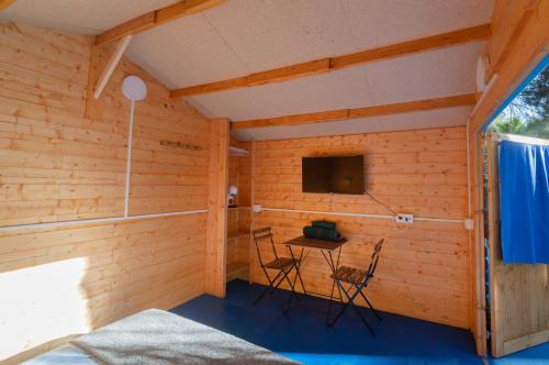 Zimmer mit einem kleinen Tisch und einem TV in der Unterkunft ZALUAY - Habitaciones de madera in Isla Cristina