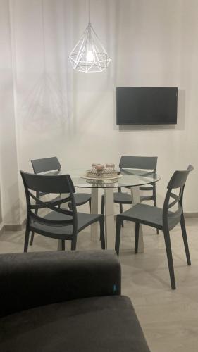 una sala da pranzo con tavolo, sedie e TV di La Casa di EMMA a Corsico