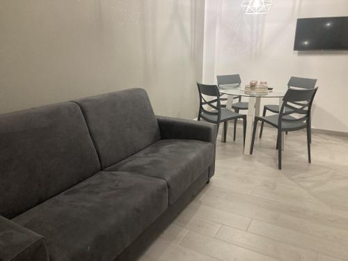 a living room with a couch and a table with chairs at La Casa di EMMA in Corsico