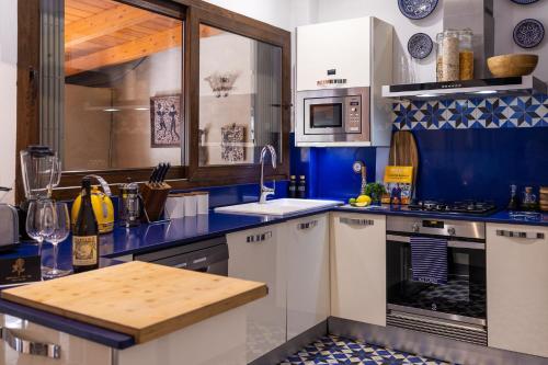 una cocina azul y blanca con encimera en Portrait Boutique Guesthouse, en Valencia