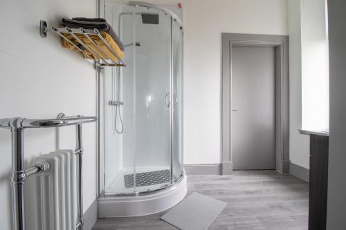a shower in a bathroom with a glass shower at Lugton Rooms in Beith