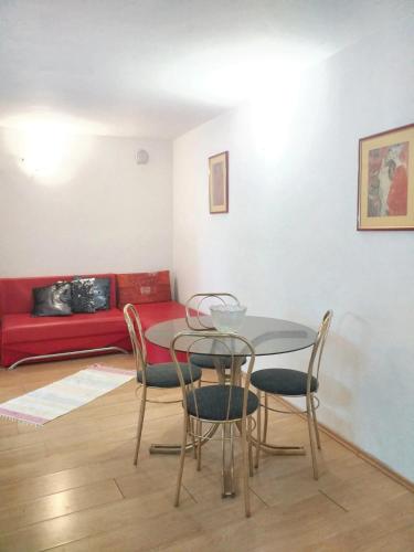 un tavolo e sedie in un soggiorno con divano rosso di Cosy Apartment in Vir with Terrace a Vir (Puntadura)