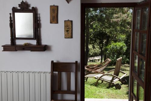 an open door to a yard with a mirror and chairs at La Pergola in Diaccialone