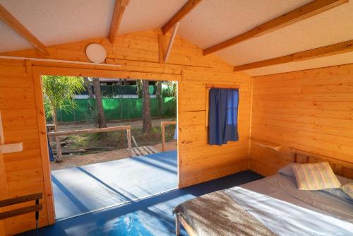 um quarto com uma cama num chalé de madeira em ZALUAY - Habitaciones de madera em Isla Cristina