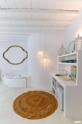 a white kitchen with a wooden circle on the floor at Nikis Home in Mikonos