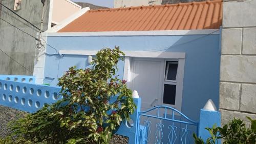 una casa azul con una puerta blanca y una valla en CasaMrichica1 en Ribeira Grande