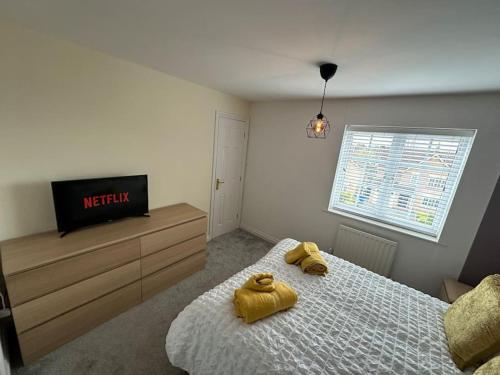 a bedroom with a bed with two yellow towels on it at Mmc serviced accommodation 2 in Leigh