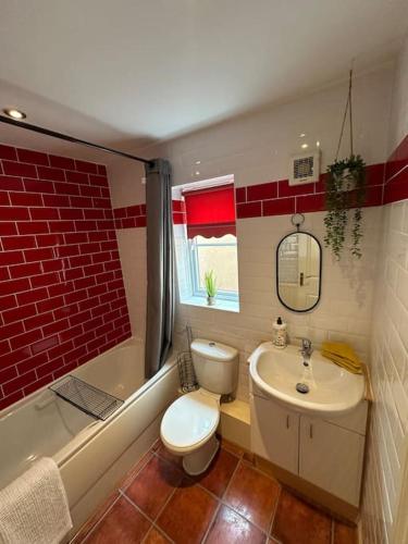 a bathroom with a toilet and a sink and a tub at Mmc serviced accommodation 2 in Leigh