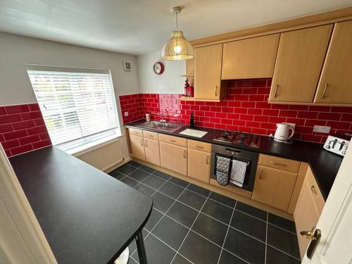 cocina con pared de ladrillo rojo en Mmc serviced accommodation 2, en Leigh