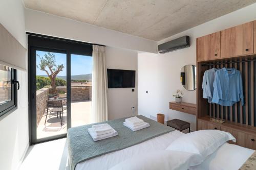 a bedroom with a large bed and a balcony at Atria luxury experience in Kattavía