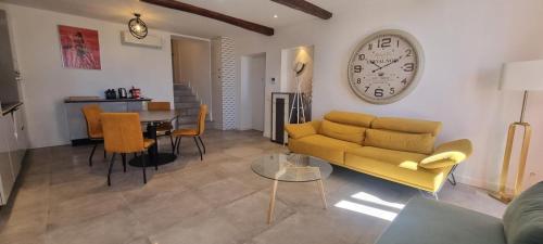 un salon avec un canapé et une horloge au mur dans l'établissement M.M.R. Gioma, à Cannes