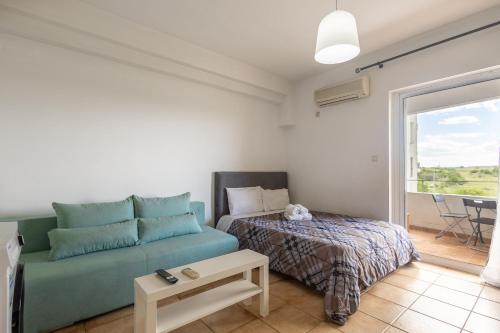 een woonkamer met een bank en een bed bij Elia mini suites 6 in Larisa