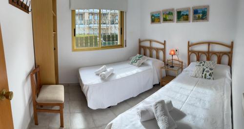 a bedroom with two beds and a window at Apartamentos la Dorada in Cambrils