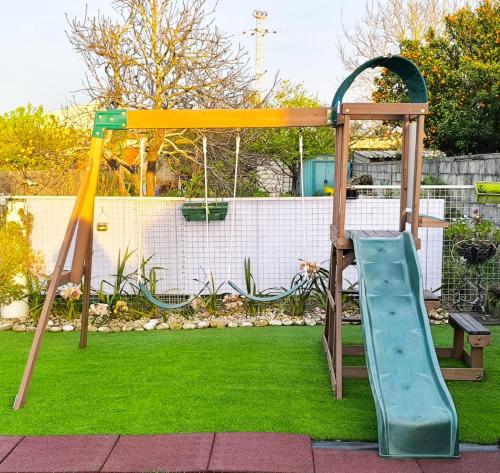a playground with a slide in a yard at Herama Garden Guesthouse in Vila Nova de Gaia