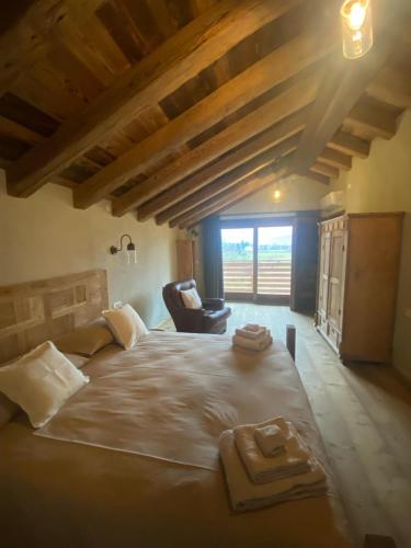 a bedroom with a large bed with two towels on it at Chalet Valchiavenna in San Cassiano