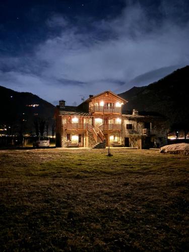 a large house with lights in a field at night at Chalet Valchiavenna in San Cassiano