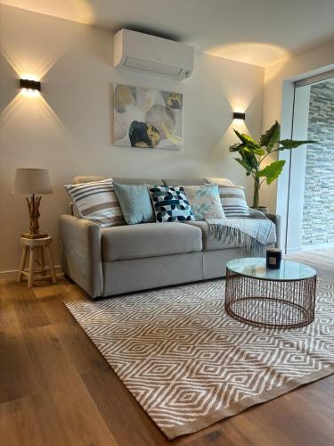 un salon avec un canapé et une table dans l'établissement Appartement neuf, à Saint-Laurent-du-Var