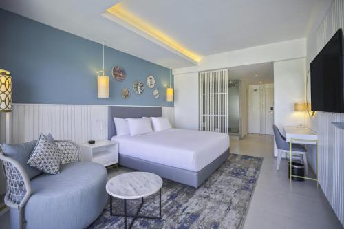 a hotel room with a bed and a couch and a table at Hilton Skanes Monastir Beach Resort in Monastir