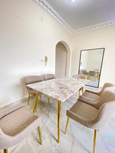 a dining room with a marble table and chairs at مشار العلا AL ULA in Al-ʿUla
