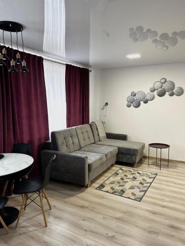 a living room with a couch and a table at Likos apartamentai in Anykščiai