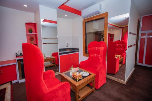 a room with red chairs and a table and a mirror at Hotel Pokhara Village & SPA in Pokhara
