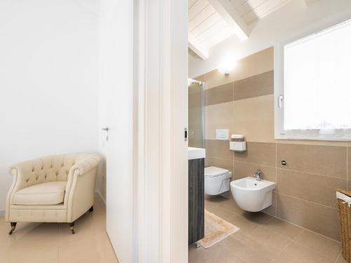 La salle de bains est pourvue d'une chaise, d'un lavabo et de toilettes. dans l'établissement Casa Giovele, à Selargius