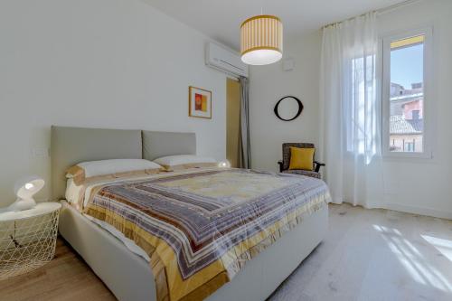 Un dormitorio blanco con una cama grande y una ventana en Casa Drago, en Bolonia