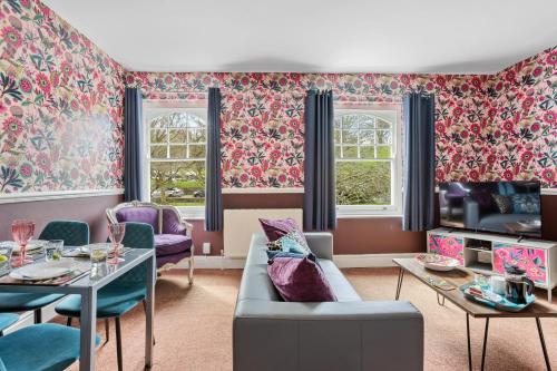 a living room with pink floral wallpaper at Harbour Heights Plymouth - Centrally located - Parking - Ocean City Retreats in Plymouth