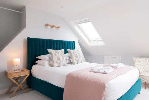 a bedroom with a bed with a green headboard at Cosy Loft Retreat, King Bed, En-suite, Kitchenette, Homestay in Brighton & Hove