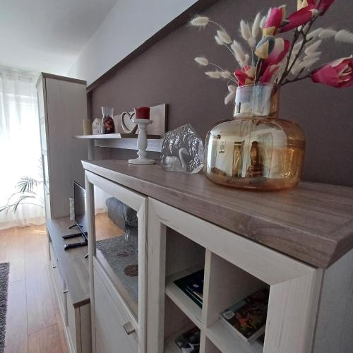 a table with a vase on it with flowers in it at Apartman West Side in Zaprešić