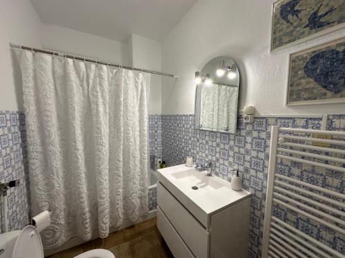 a bathroom with a sink and a toilet and a shower at Rose's Cottage Foz in Foz do Arelho