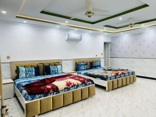 two beds are in a room with at Zaib Guest House for Families Only in E-11 Islamabad in Islamabad