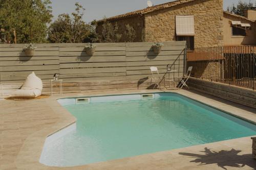 - une piscine dans un jardin avec un mur en bois dans l'établissement Casa Diana B, à Sant Jordi Desvalls