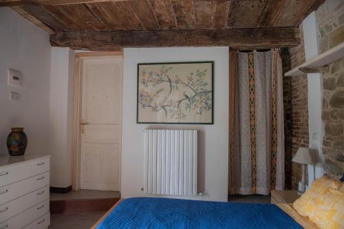 a bedroom with a bed and a painting on the wall at La casa del Colle in San Ginesio